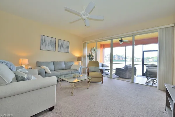 a living room with furniture and a large window with balcony view