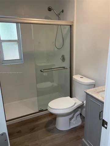 a white toilet sitting next to a shower