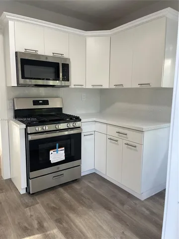 a kitchen with white cabinets and stainless steel appliances