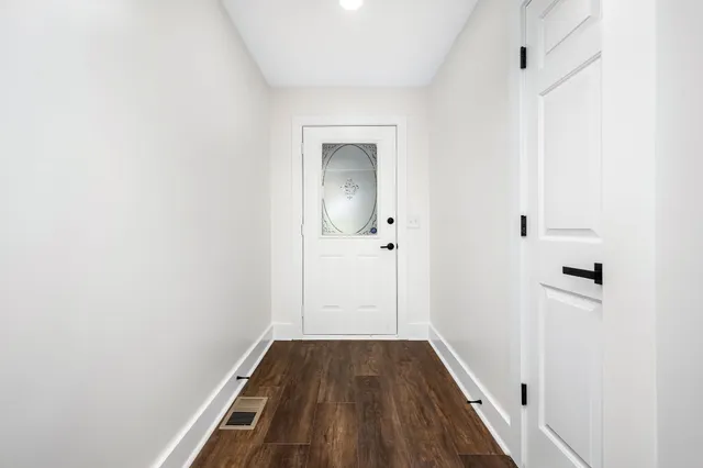 a view of a hallway with wooden floor