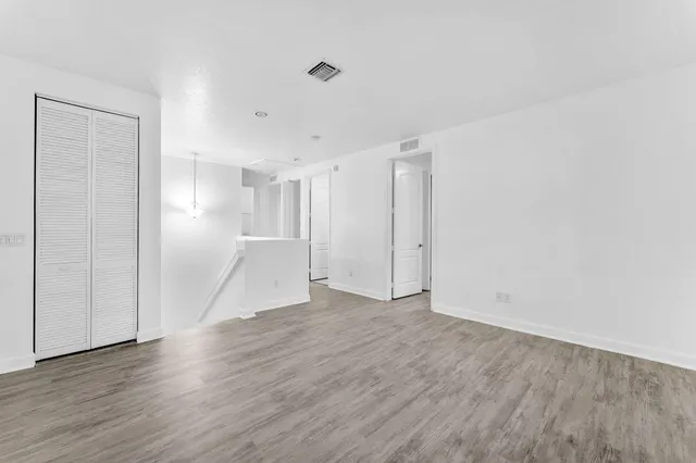a view of an empty room with wooden floor