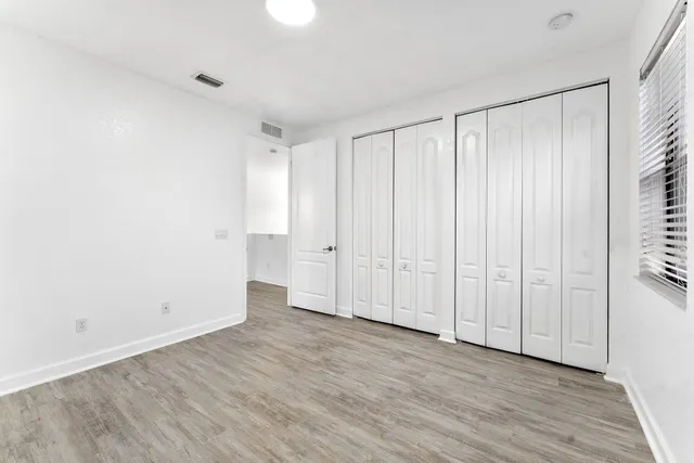 a view of an empty room with wooden floor