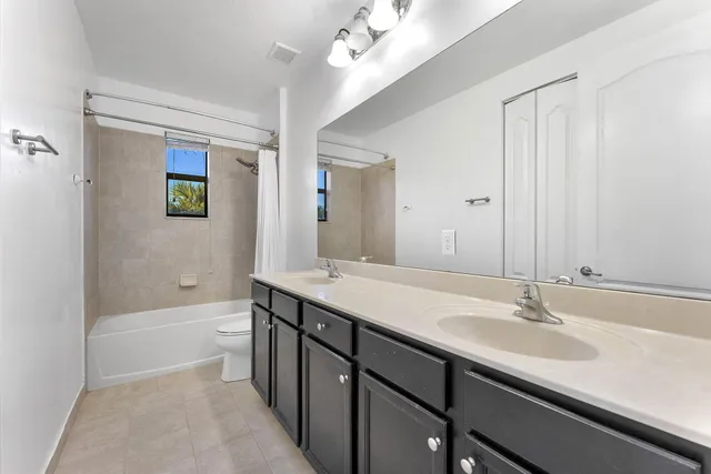 a bathroom with a sink a toilet a mirror and shower