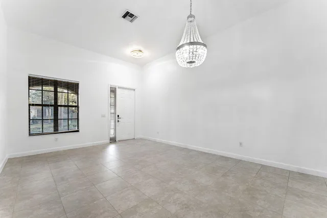 an empty room with windows and cabinet