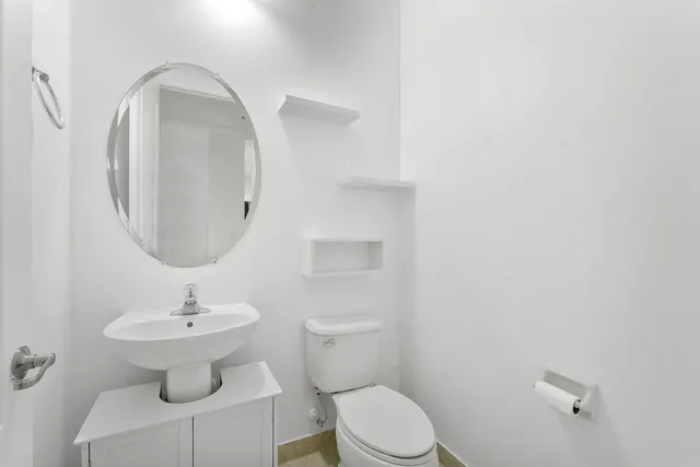 a bathroom with a toilet sink and mirror