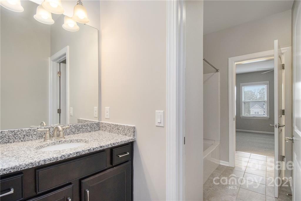 7007 Fallondale Road Waxhaw, NC 28173 - Photo 20 of 24 a bathroom with a granite countertop sink and a mirror