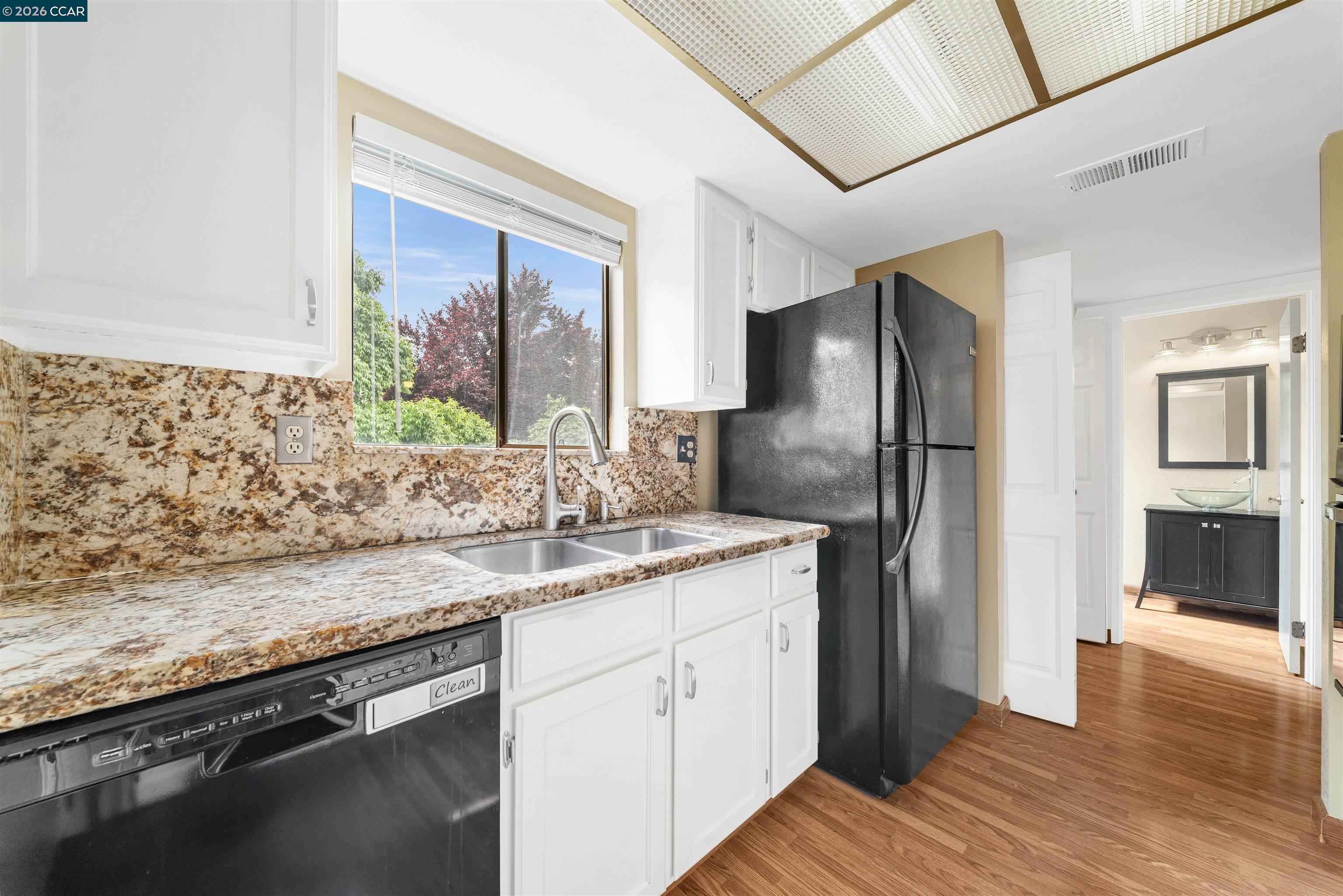 2055 Sierra Road, Unit 106 Concord, CA 94518 - Photo 15 of 37 a kitchen with stainless steel appliances granite countertop a refrigerator a sink and dishwasher with wooden floor