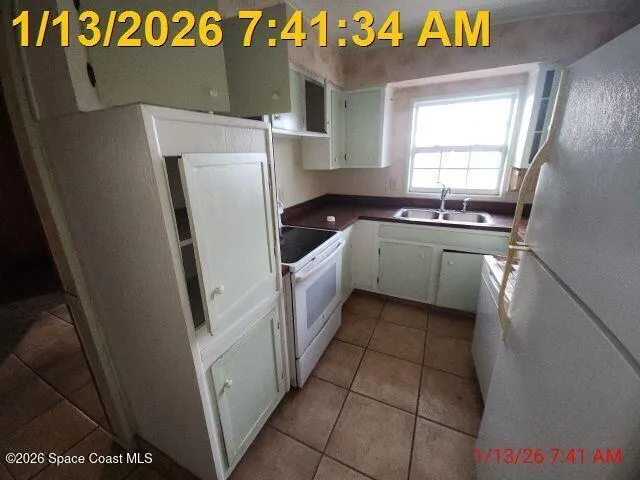 a kitchen with a sink a refrigerator and window