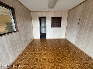 a view of a hallway with wooden floor and a bathroom