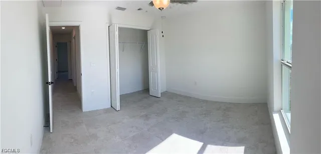 an empty room with closet and mirror