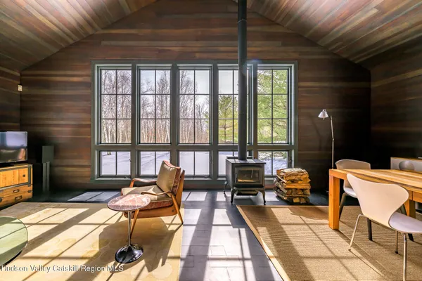 a view of a furniture in a big room with wooden floor and windows