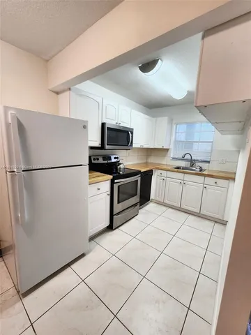 a kitchen with stainless steel appliances granite countertop a refrigerator stove a sink and dishwasher