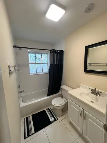 a bathroom with a sink a toilet a tub and shower