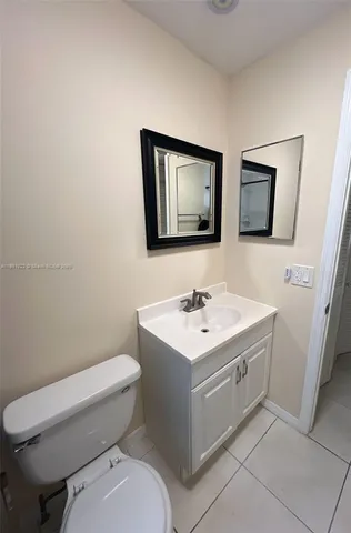 a bathroom with a toilet a sink and mirror