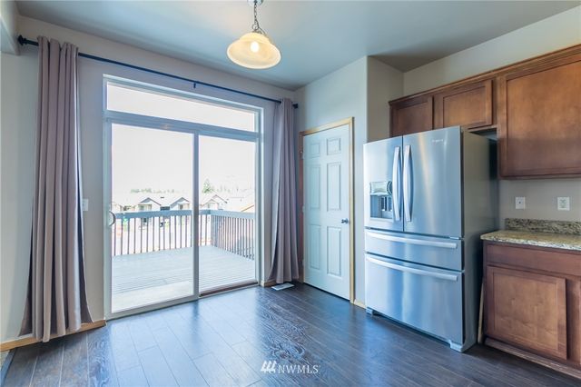 a kitchen with stainless steel appliances a refrigerator and wooden floor