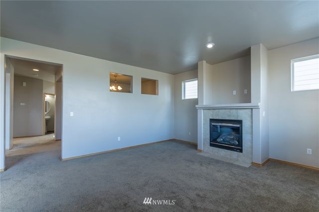 an empty room with fireplace and fan