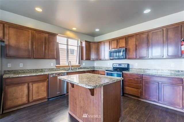 a kitchen with cabinets appliances a sink and a counter top space