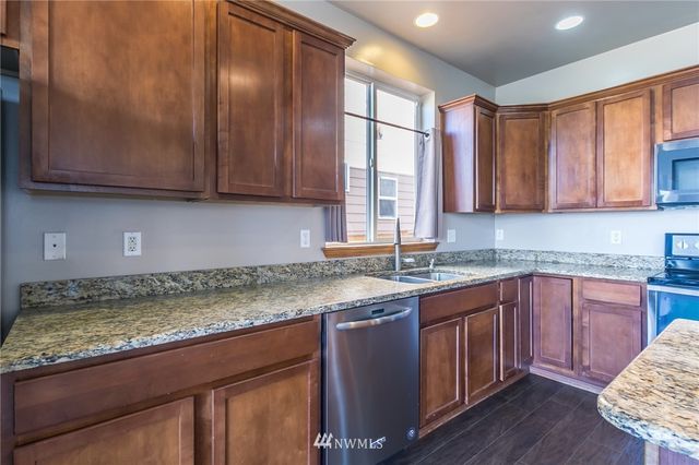 a kitchen with granite countertop cabinets sink and window