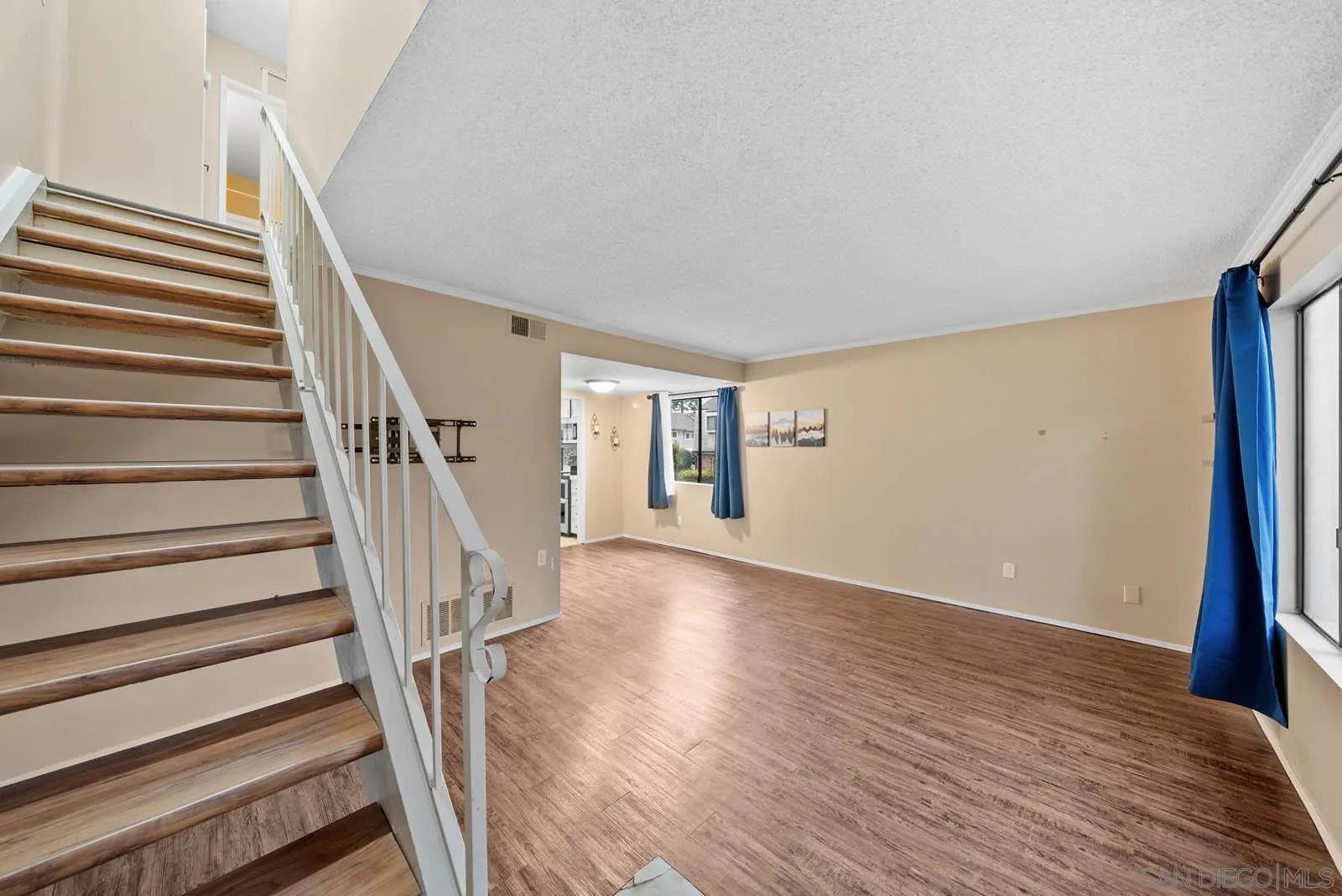 11911 Royal Road, Unit G El Cajon, CA 92021 - Photo 5 of 31 a view of staircase with wooden floor and white walls