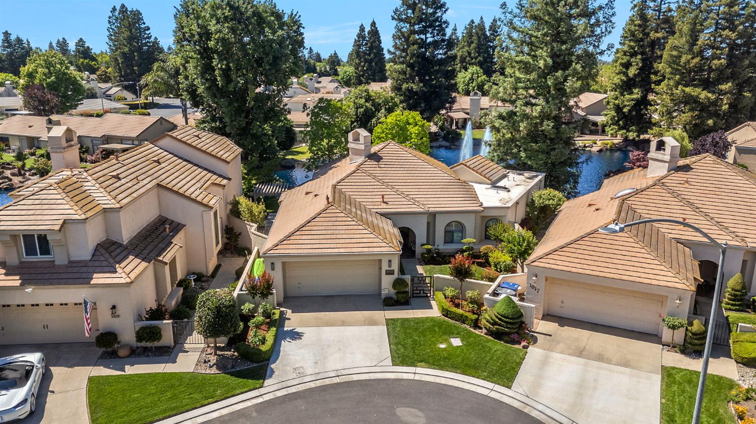 1013 Copper Lake Court Modesto, CA 95355 - Photo 32 of 66 a view of a white house with a yard plants and large tree