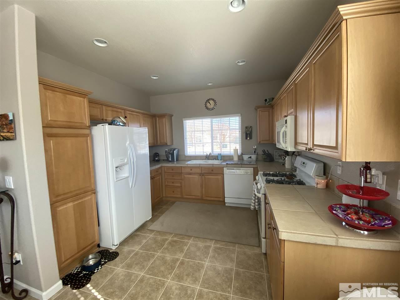 1790 Ornellaia Way Reno, NV 89521 - Photo 5 of 22 a kitchen with a refrigerator a sink and wooden cabinets