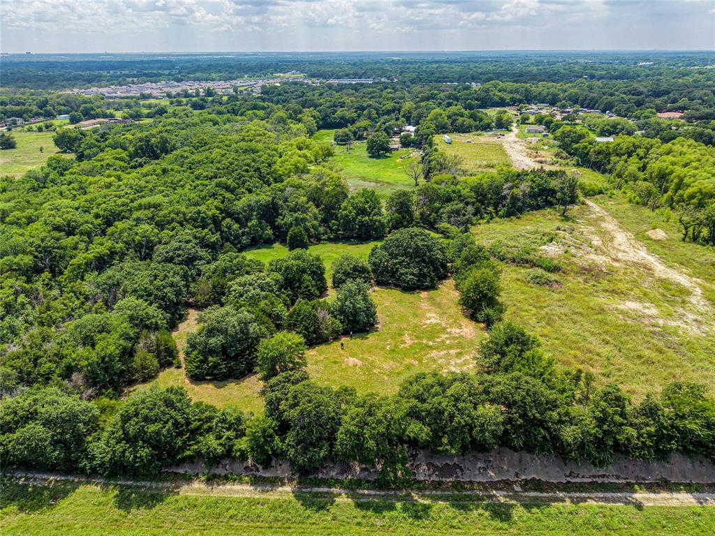 1900 Haymarket Road Dallas, TX 75253 - Photo 10 of 20 Expansive aerial view of a verdant landscape featuring mature trees, open grassy areas, and distant residential structures