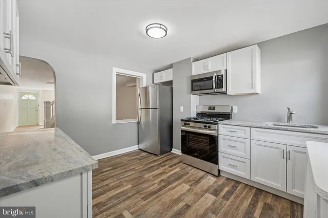 a kitchen with granite countertop a stove top oven and sink