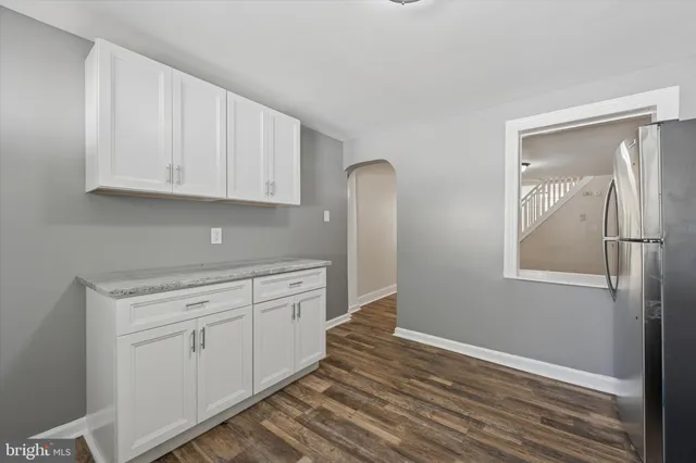 a kitchen with granite countertop white cabinets and white appliances