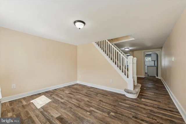 a view of a hallway with wooden floor and staircase