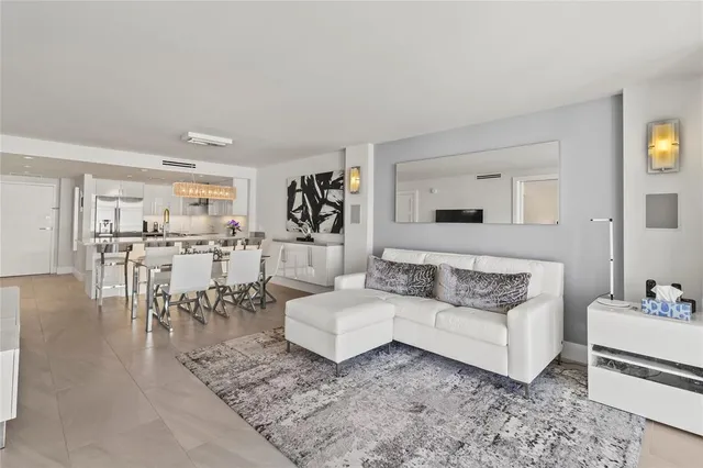 a living room with furniture and view of kitchen