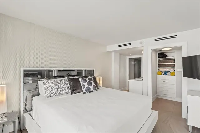 a large bed sitting in a bedroom and table chair