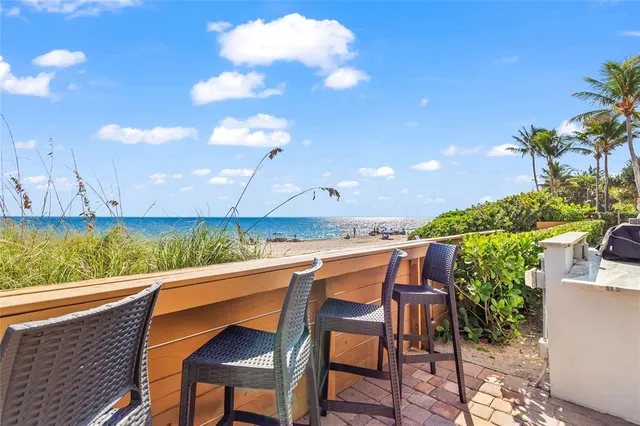 a view of a patio with table and chairs with wooden floor and fence