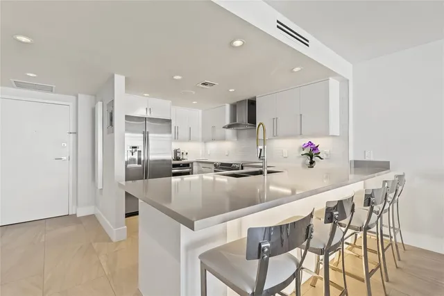 a kitchen with kitchen island granite countertop a sink and cabinets