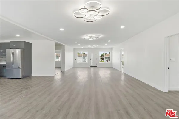 a view of a room with wooden floor and a ceiling fan