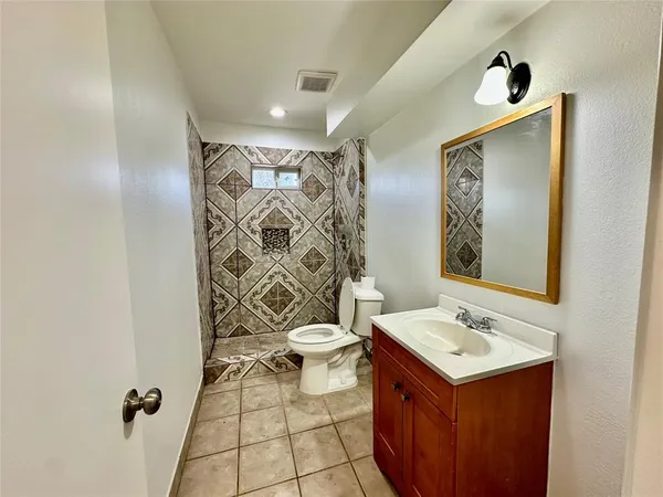 a bathroom with a sink and mirror with toilet
