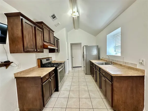 a kitchen with a stove sink and cabinets