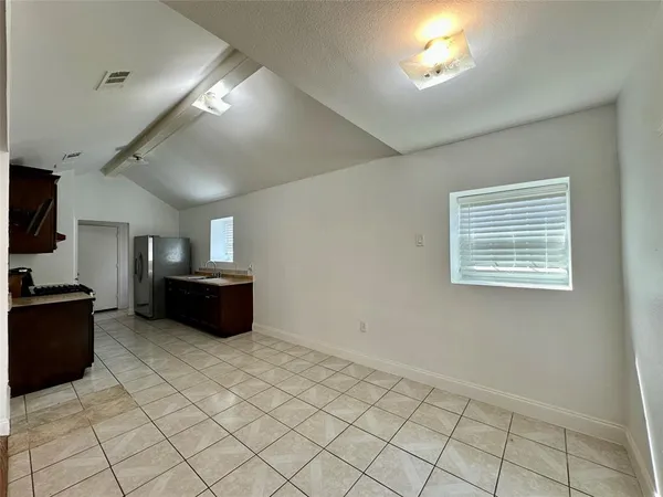 a view of kitchen with sink refrigerator and cabinets