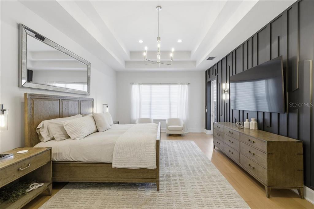 2829 Coastal Range Way Lutz, FL 33559 - Photo 33 of 64 a bedroom with a bed a chandelier and dresser