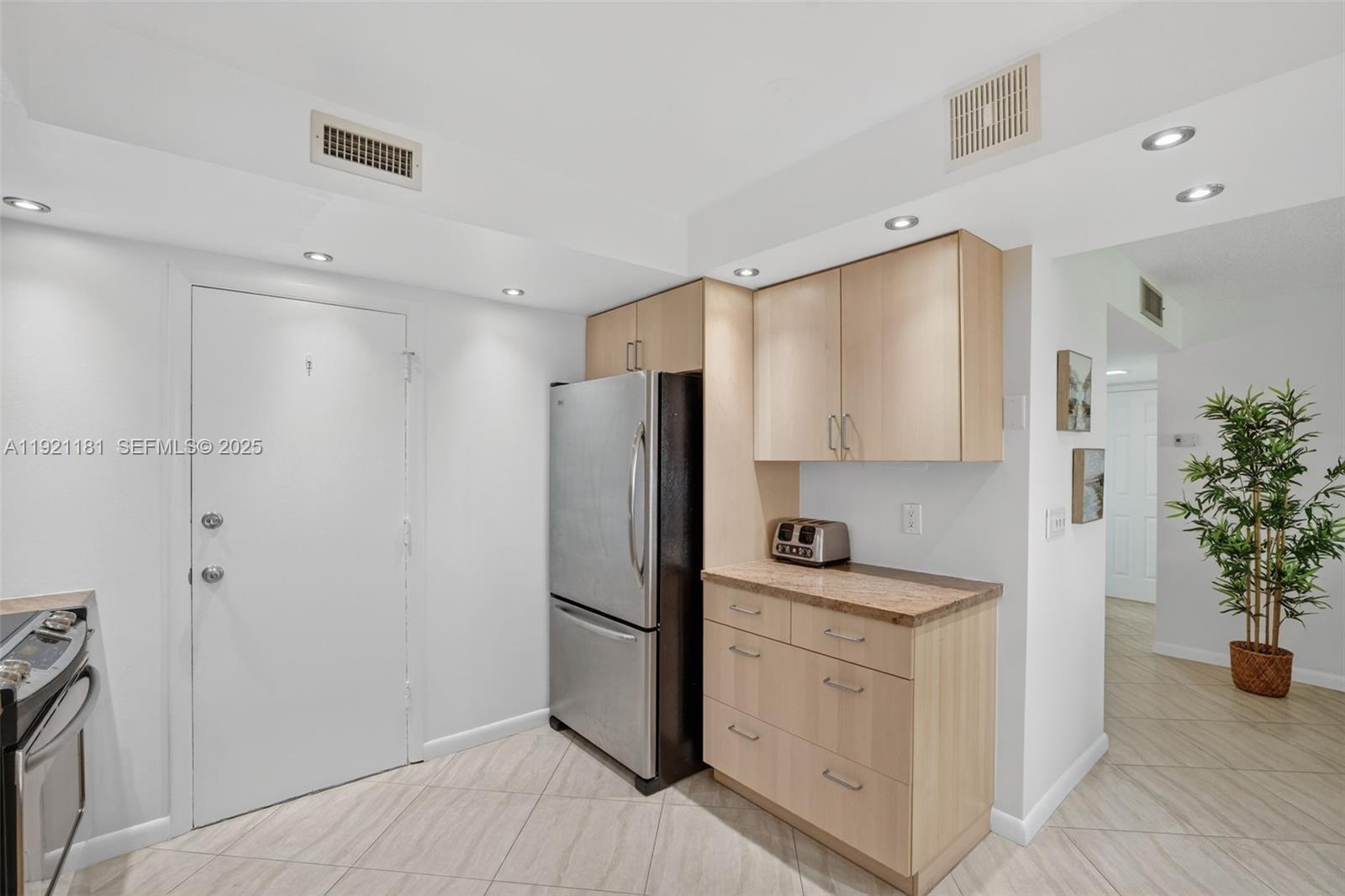 200 Diplomat Parkway, Unit 531 Hallandale Beach, FL 33009 - Photo 13 of 45 a kitchen with a refrigerator sink and white cabinets