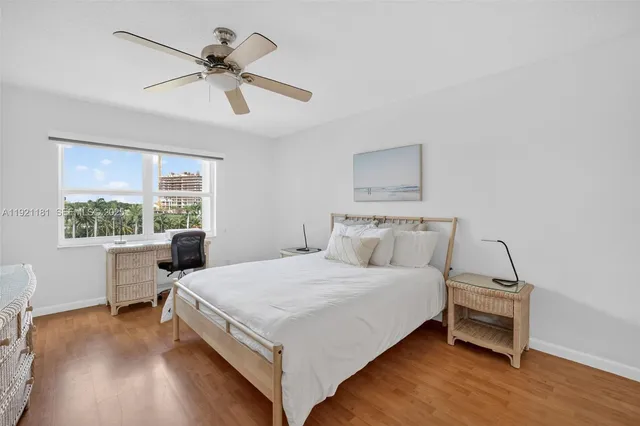 a bedroom with a large bed a flat tv screen and a dresser