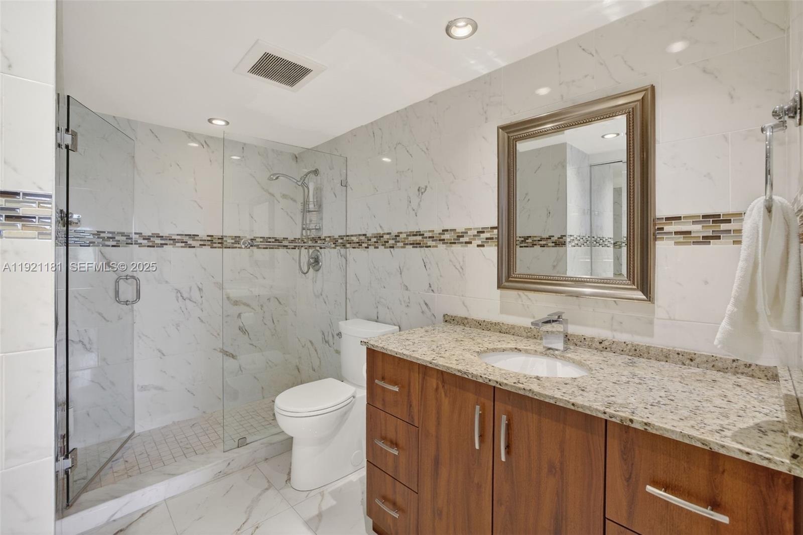 200 Diplomat Parkway, Unit 531 Hallandale Beach, FL 33009 - Photo 21 of 45 a bathroom with a granite countertop sink a toilet and shower