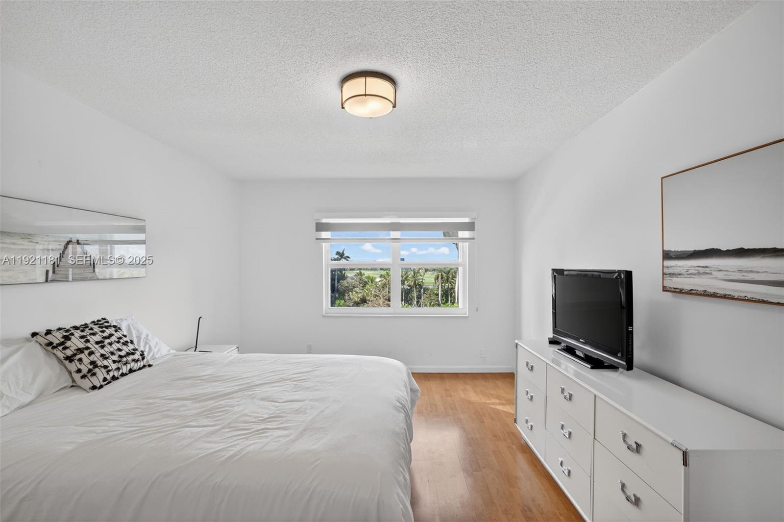 200 Diplomat Parkway, Unit 531 Hallandale Beach, FL 33009 - Photo 24 of 45 a bedroom with a bed and a flat screen tv