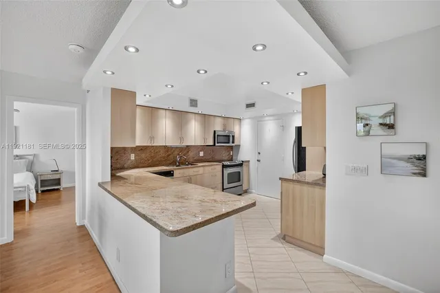a kitchen with stainless steel appliances granite countertop a sink and a refrigerator