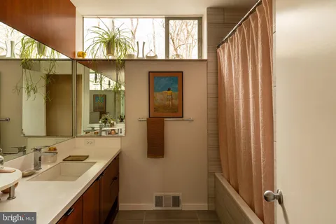 a bedroom with a bed and large windows