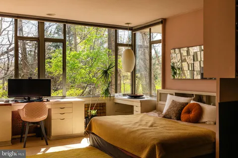 a living room with furniture and floor to ceiling windows
