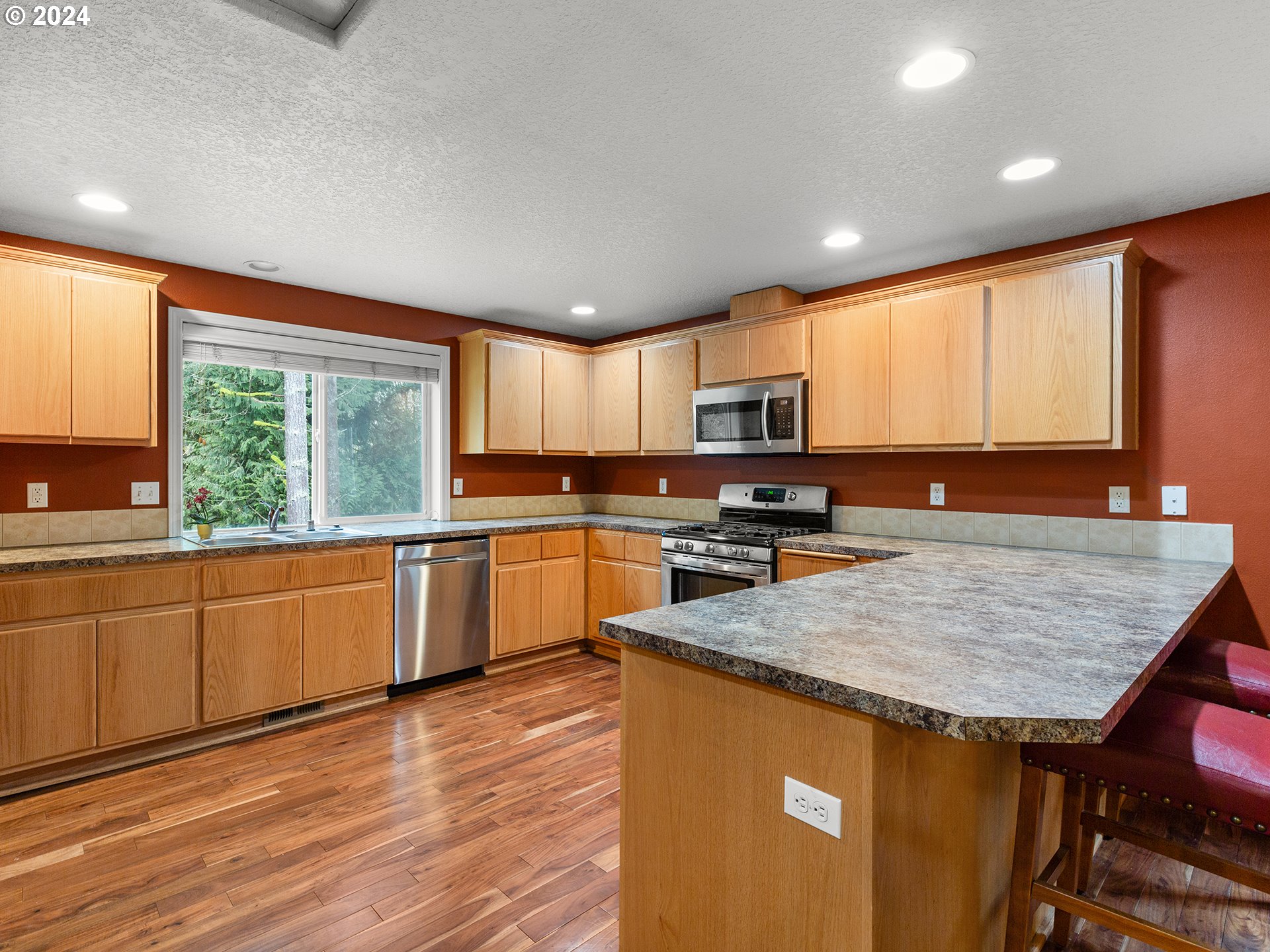 2931 South Cedar Ridge Drive Ridgefield, WA 98642 - Photo 5 of 22 a kitchen with stainless steel appliances granite countertop wooden cabinets a stove top oven a sink and dishwasher with wooden floor