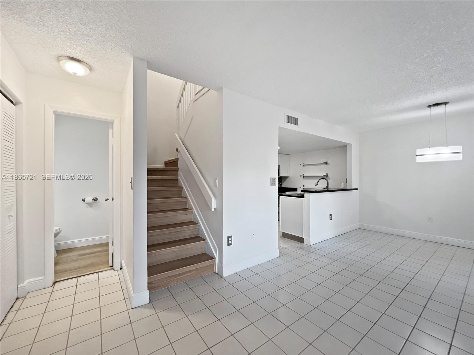 8515 Northwest 3rd Lane, Unit 1109 Miami, FL 33126 - Photo 5 of 14 a view of a kitchen with wooden cabinet and a refrigerator