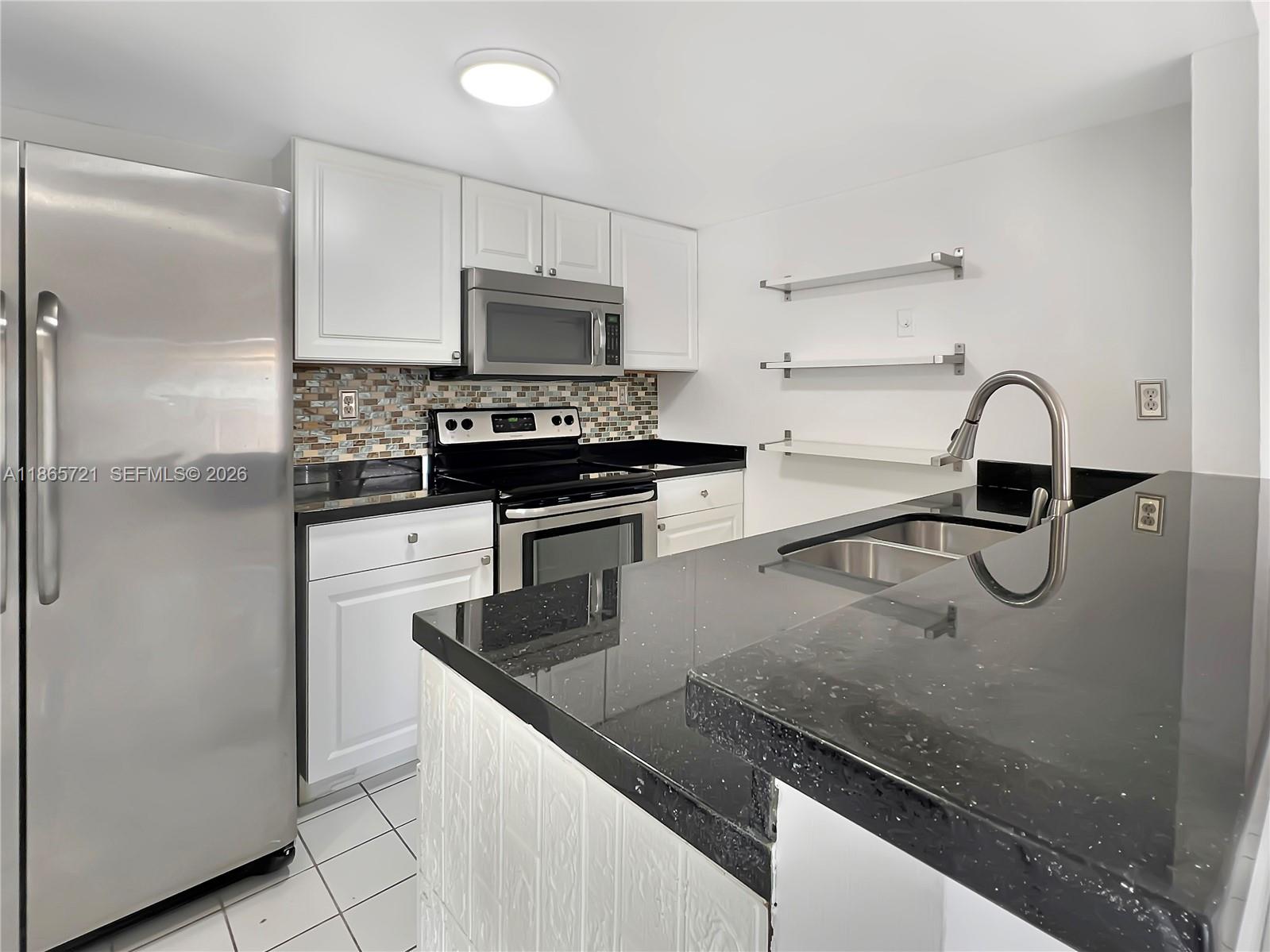 8515 Northwest 3rd Lane, Unit 1109 Miami, FL 33126 - Photo 7 of 14 a kitchen with stainless steel appliances granite countertop a sink and a refrigerator