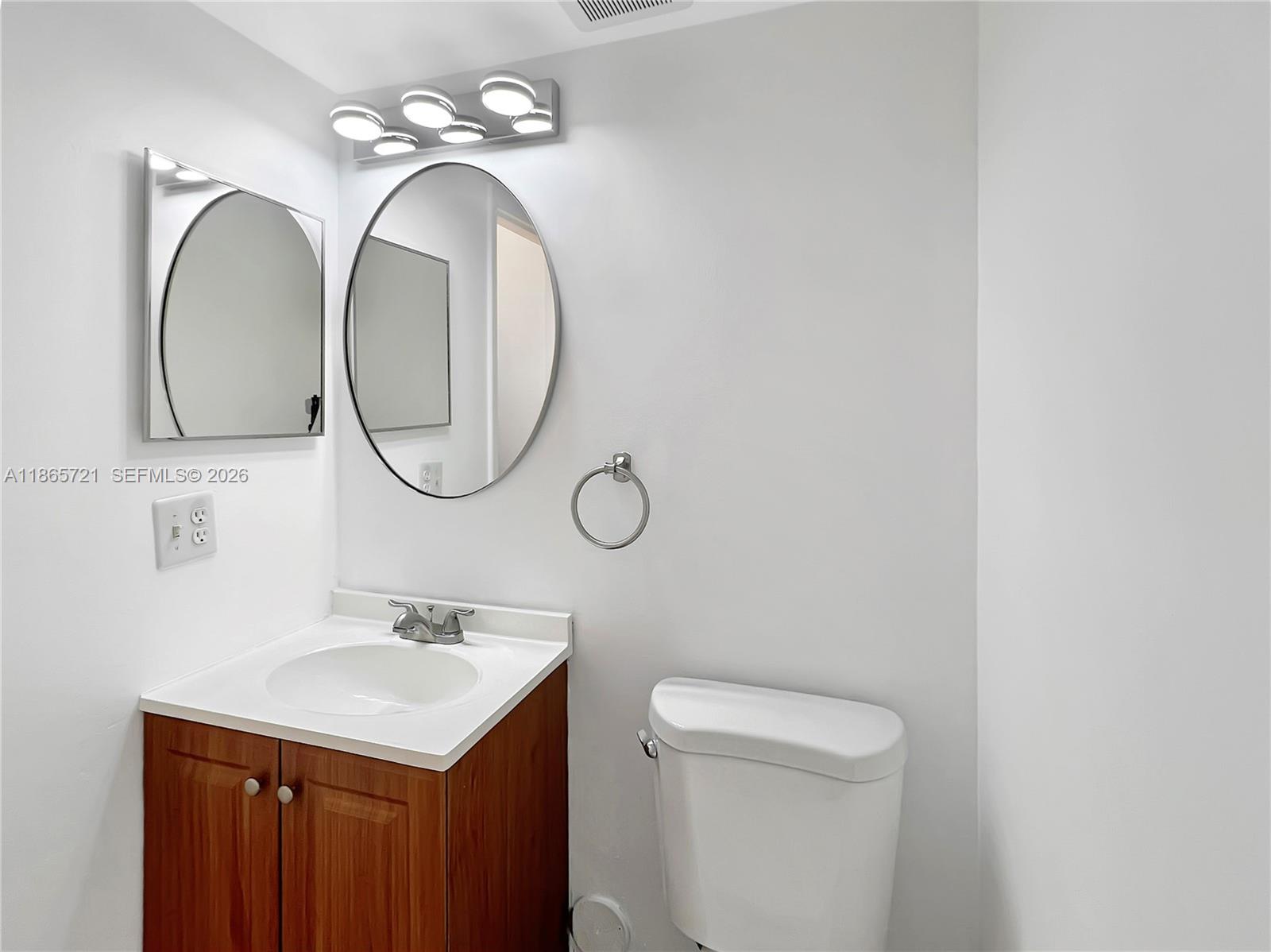 8515 Northwest 3rd Lane, Unit 1109 Miami, FL 33126 - Photo 8 of 14 a bathroom with a sink mirror and toilet