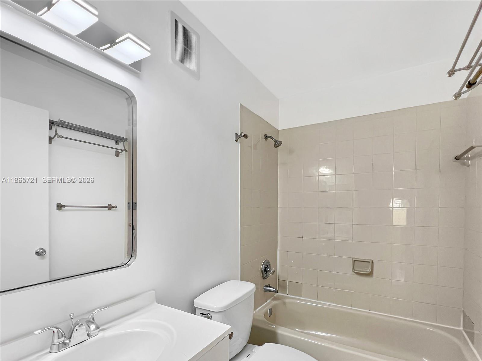 8515 Northwest 3rd Lane, Unit 1109 Miami, FL 33126 - Photo 9 of 14 a bathroom with a sink and mirror with toilet